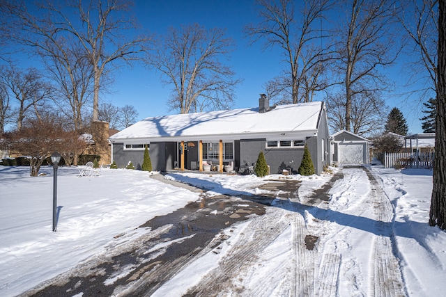 mid-century modern home featuring a detached garage and a chimney