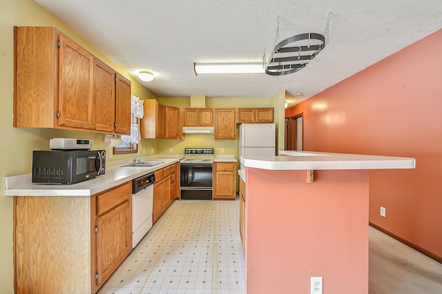 kitchen featuring a breakfast bar area, white appliances, a sink, light countertops, and a center island