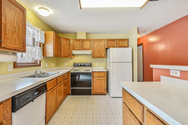 kitchen featuring under cabinet range hood, white appliances, a sink, light countertops, and light floors