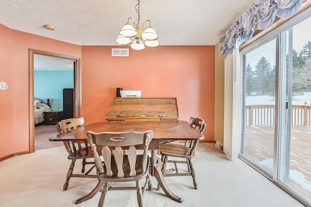 dining area with a textured ceiling, light carpet, visible vents, baseboards, and an inviting chandelier