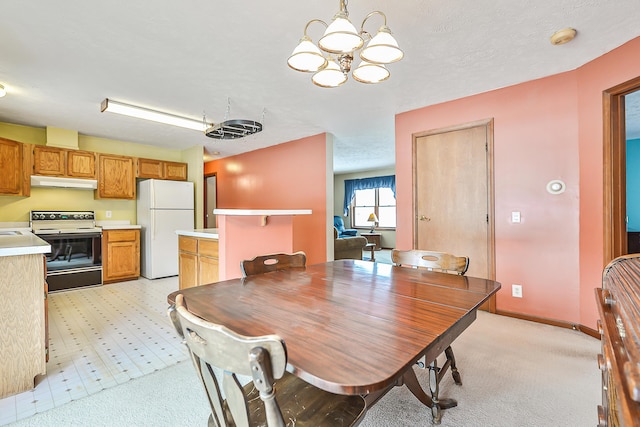 dining room featuring a chandelier, light floors, and baseboards