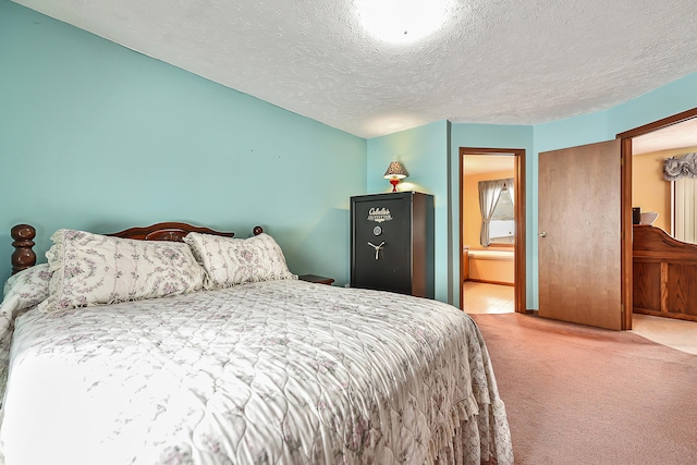 bedroom with carpet flooring, a textured ceiling, and ensuite bathroom