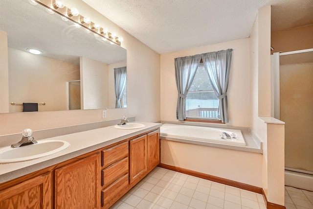 bathroom with double vanity, a garden tub, a shower stall, and a sink