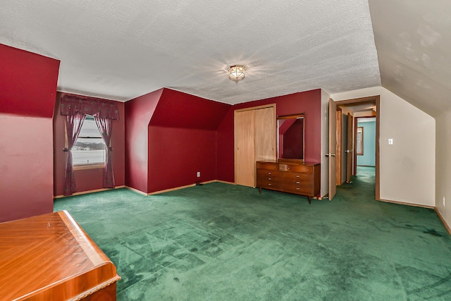 bonus room with lofted ceiling, baseboards, dark carpet, and a textured ceiling