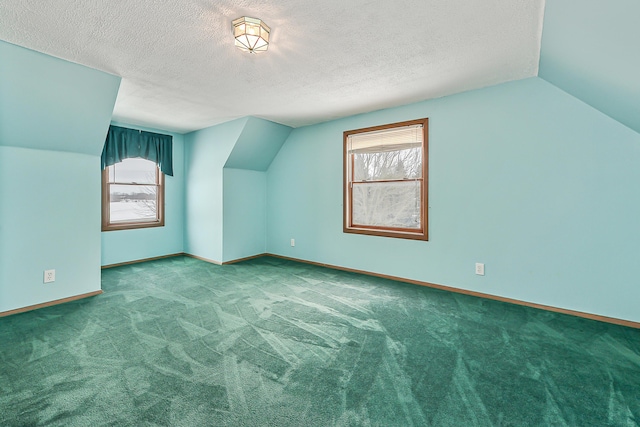 additional living space featuring a textured ceiling, carpet, and baseboards