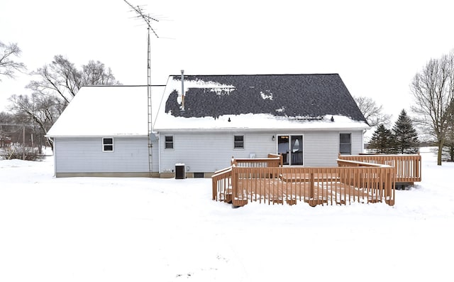 snow covered back of property featuring a deck and central AC