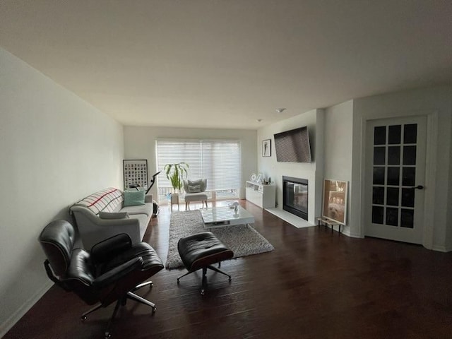 sitting room featuring wood finished floors and a fireplace with flush hearth