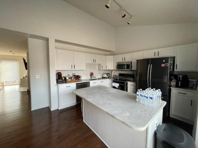 kitchen with decorative backsplash, dark wood-type flooring, white cabinets, a kitchen island, and black appliances