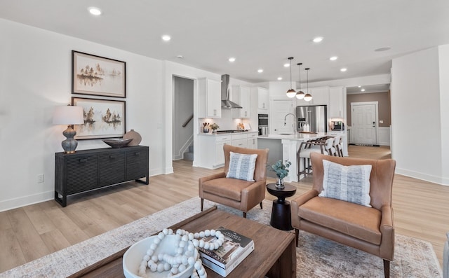 living room with baseboards, stairway, light wood-style flooring, and recessed lighting