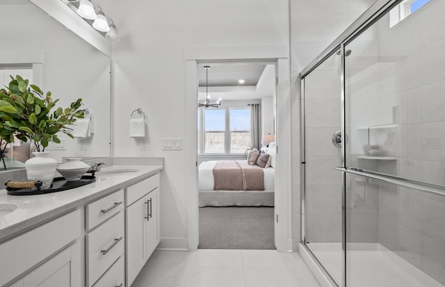 ensuite bathroom featuring ensuite bathroom, a sink, a shower stall, tile patterned floors, and double vanity