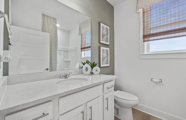 full bathroom with toilet, wood finished floors, vanity, and baseboards