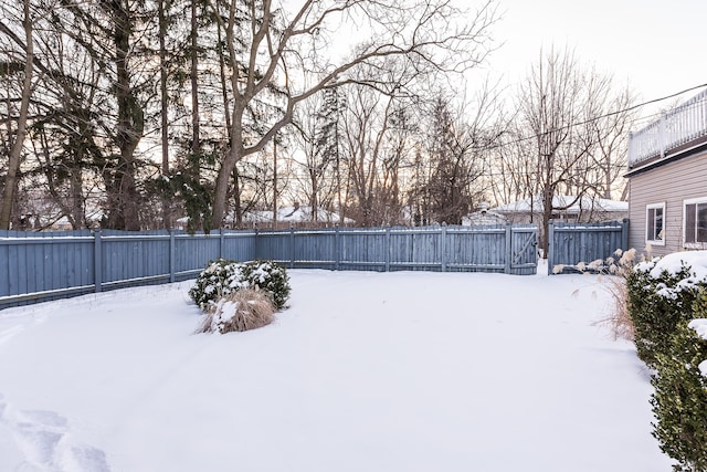 yard covered in snow featuring a fenced backyard