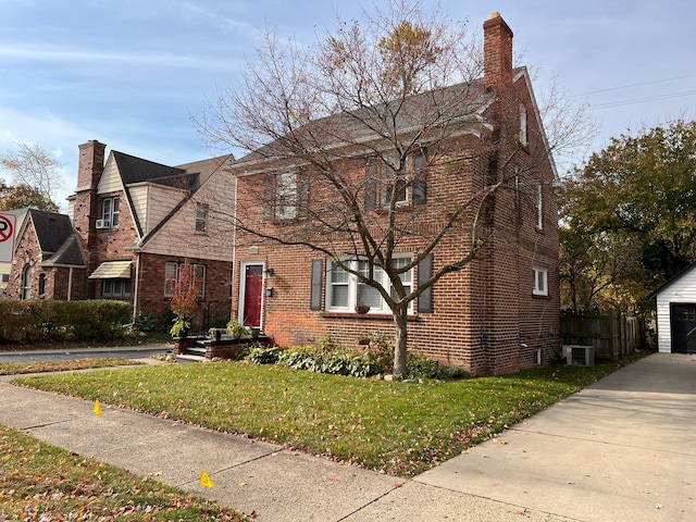 view of front of property with cooling unit, brick siding, an outdoor structure, a chimney, and a front yard