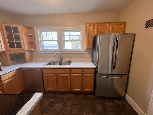 kitchen featuring open shelves, tile counters, appliances with stainless steel finishes, a sink, and baseboards