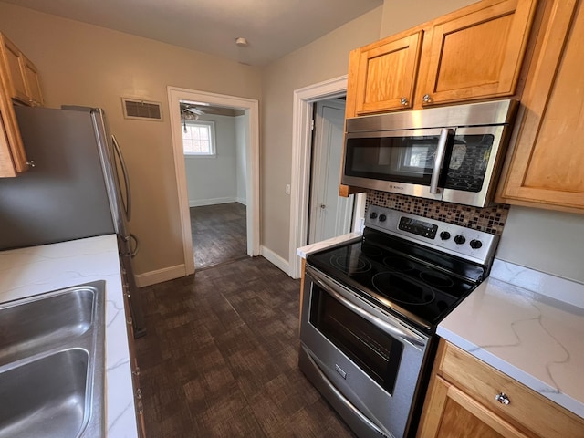 kitchen featuring visible vents, dark wood finished floors, backsplash, stainless steel appliances, and a sink