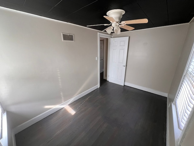 unfurnished bedroom with a ceiling fan, baseboards, visible vents, and dark wood-style flooring