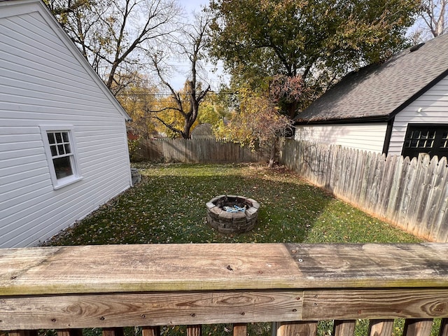 view of yard with an outdoor fire pit, a fenced backyard, and a wooden deck