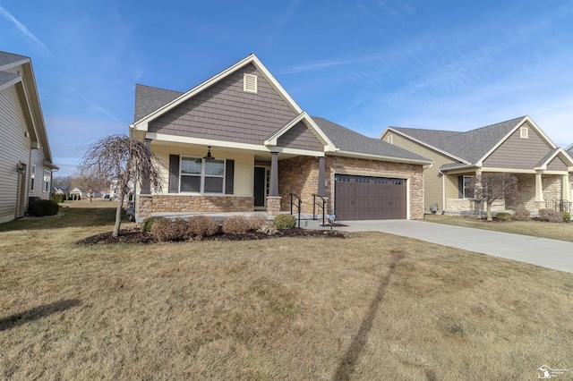 craftsman-style home featuring a porch, an attached garage, stone siding, concrete driveway, and a front yard