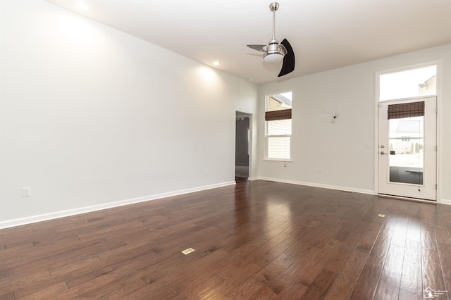 unfurnished room featuring a ceiling fan, dark wood-type flooring, and baseboards