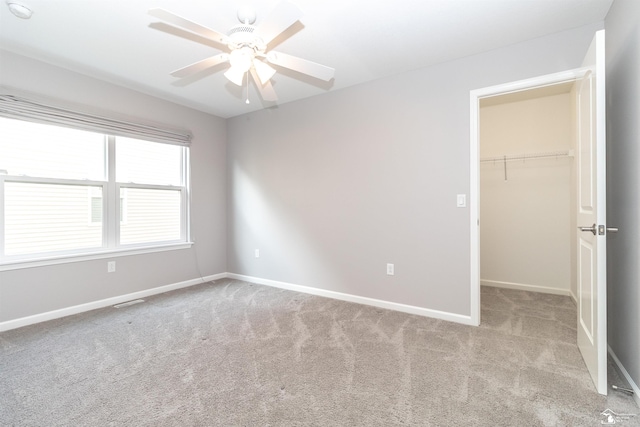 carpeted spare room with ceiling fan and baseboards