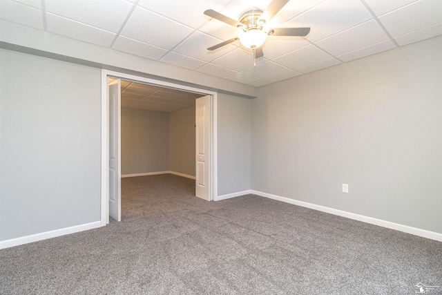 carpeted spare room with a paneled ceiling and baseboards