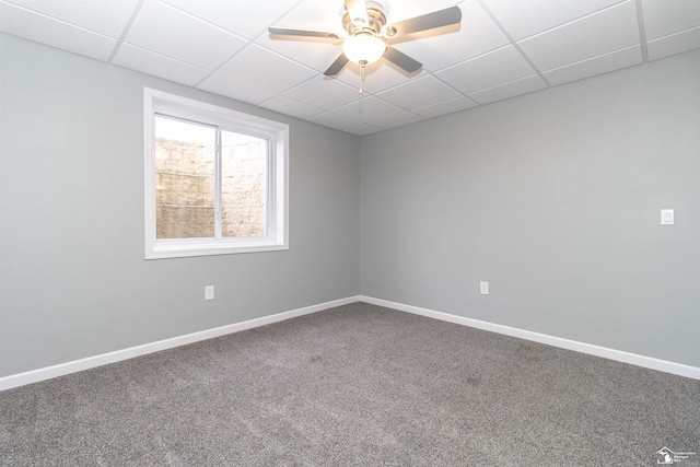 carpeted empty room with a ceiling fan, a paneled ceiling, and baseboards