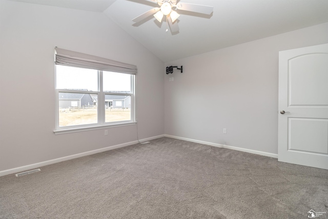 unfurnished room featuring baseboards, visible vents, vaulted ceiling, and carpet flooring