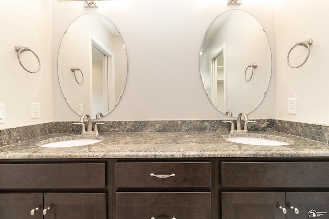 bathroom with a sink and double vanity