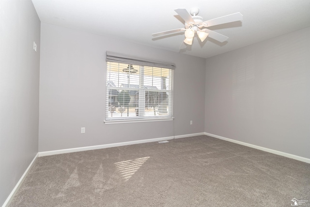 empty room featuring a ceiling fan, carpet, and baseboards