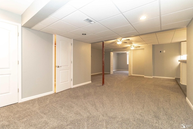 finished below grade area with a paneled ceiling, baseboards, visible vents, and carpet flooring