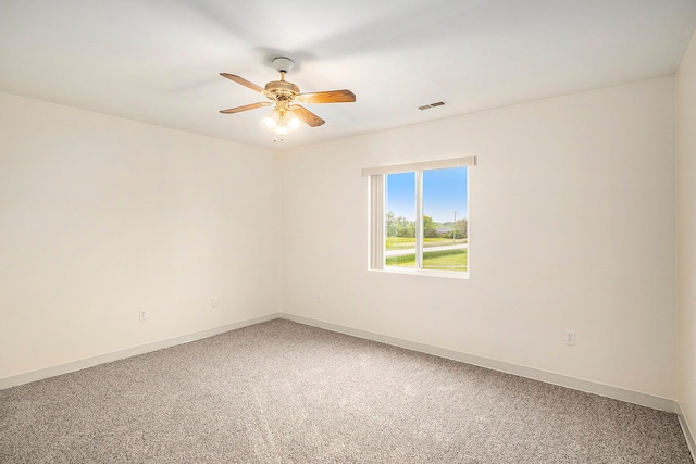 spare room featuring visible vents, ceiling fan, light carpet, and baseboards