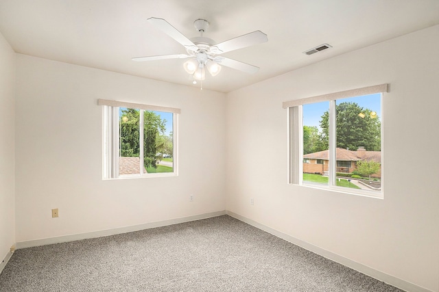 unfurnished room with baseboards, light colored carpet, visible vents, and a healthy amount of sunlight