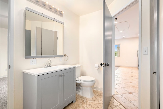 bathroom with toilet, baseboards, and vanity