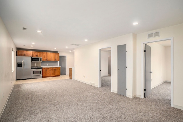 interior space with brown cabinets, stainless steel appliances, recessed lighting, visible vents, and light carpet