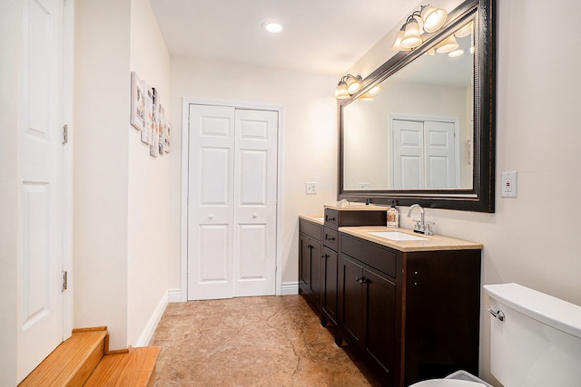 full bathroom with toilet, a closet, vanity, and baseboards