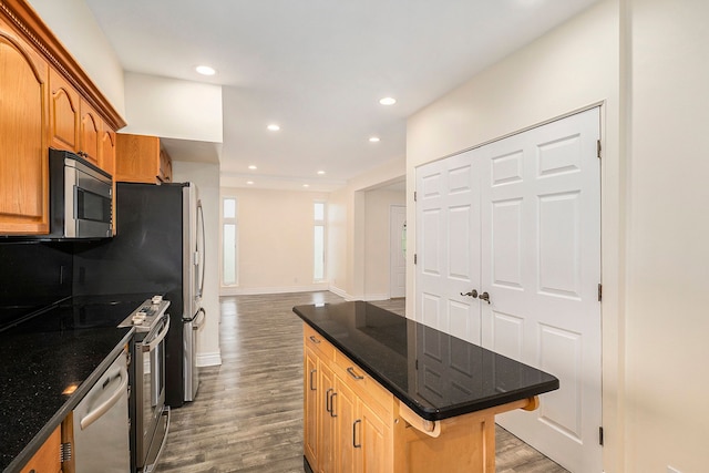 kitchen with recessed lighting, stainless steel appliances, wood finished floors, a center island, and decorative backsplash