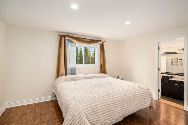 bedroom with recessed lighting, ensuite bathroom, baseboards, and wood finished floors