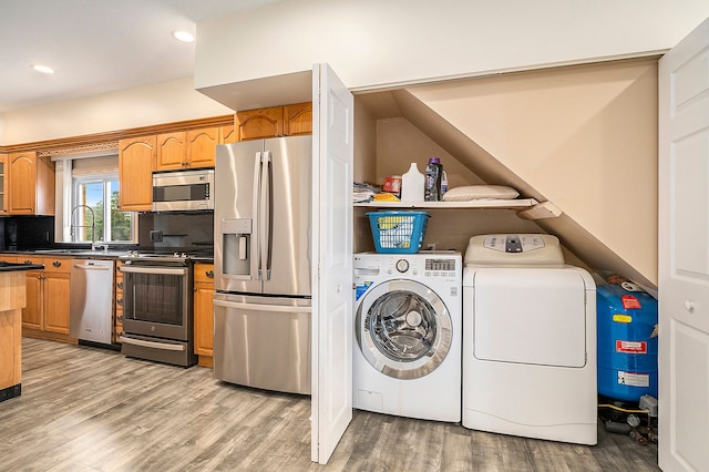 washroom with laundry area, washer and dryer, light wood-style floors, a sink, and recessed lighting