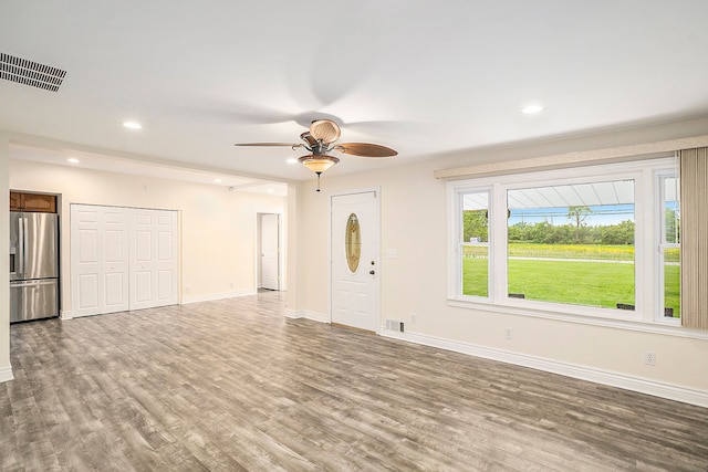 unfurnished living room with recessed lighting, visible vents, baseboards, and wood finished floors