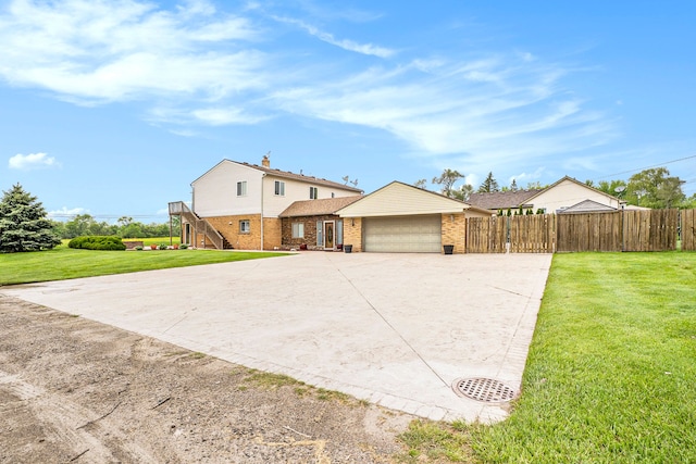 view of front of property featuring brick siding, a front yard, fence, a garage, and driveway