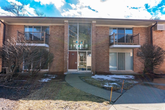 exterior space featuring brick siding and a balcony