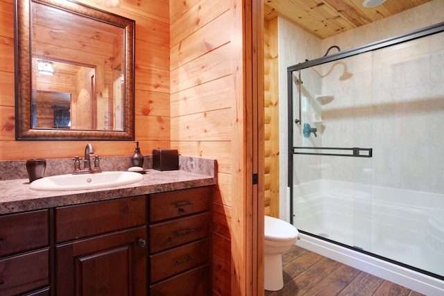 bathroom featuring toilet, a stall shower, wooden walls, and wood finished floors