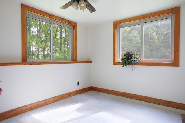 unfurnished room with concrete flooring, baseboards, and a ceiling fan