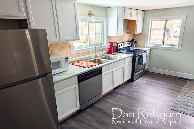 kitchen with baseboards, tasteful backsplash, appliances with stainless steel finishes, and dark wood-style flooring