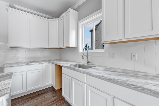 kitchen featuring a sink, white cabinetry, and light stone countertops