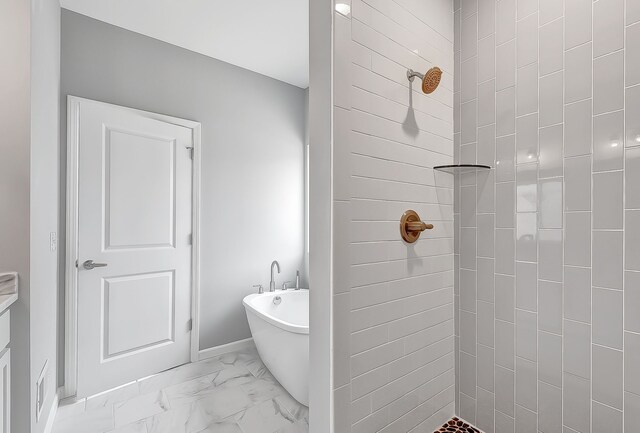 full bath with marble finish floor, a freestanding tub, and a tile shower