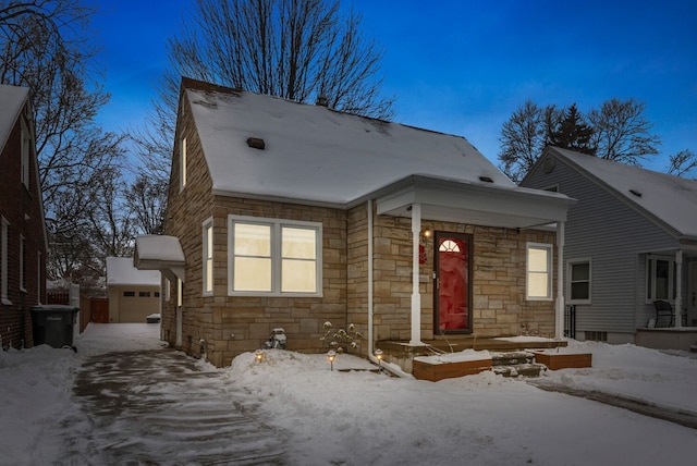 view of front of property with a garage and stone siding