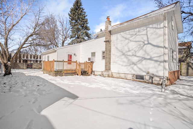 snow covered property featuring a deck and a chimney