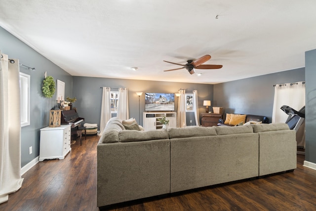 living area with ceiling fan, dark wood-type flooring, and baseboards