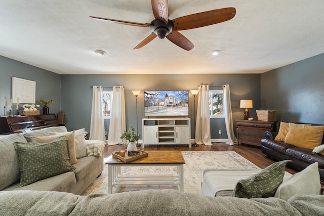 living room with ceiling fan, wood finished floors, and baseboards